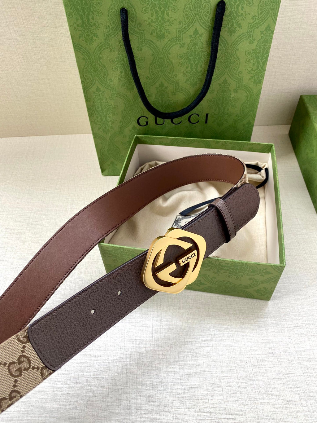 Gucci belt with brown leather strap, beige monogram panel, and gold-tone buckle