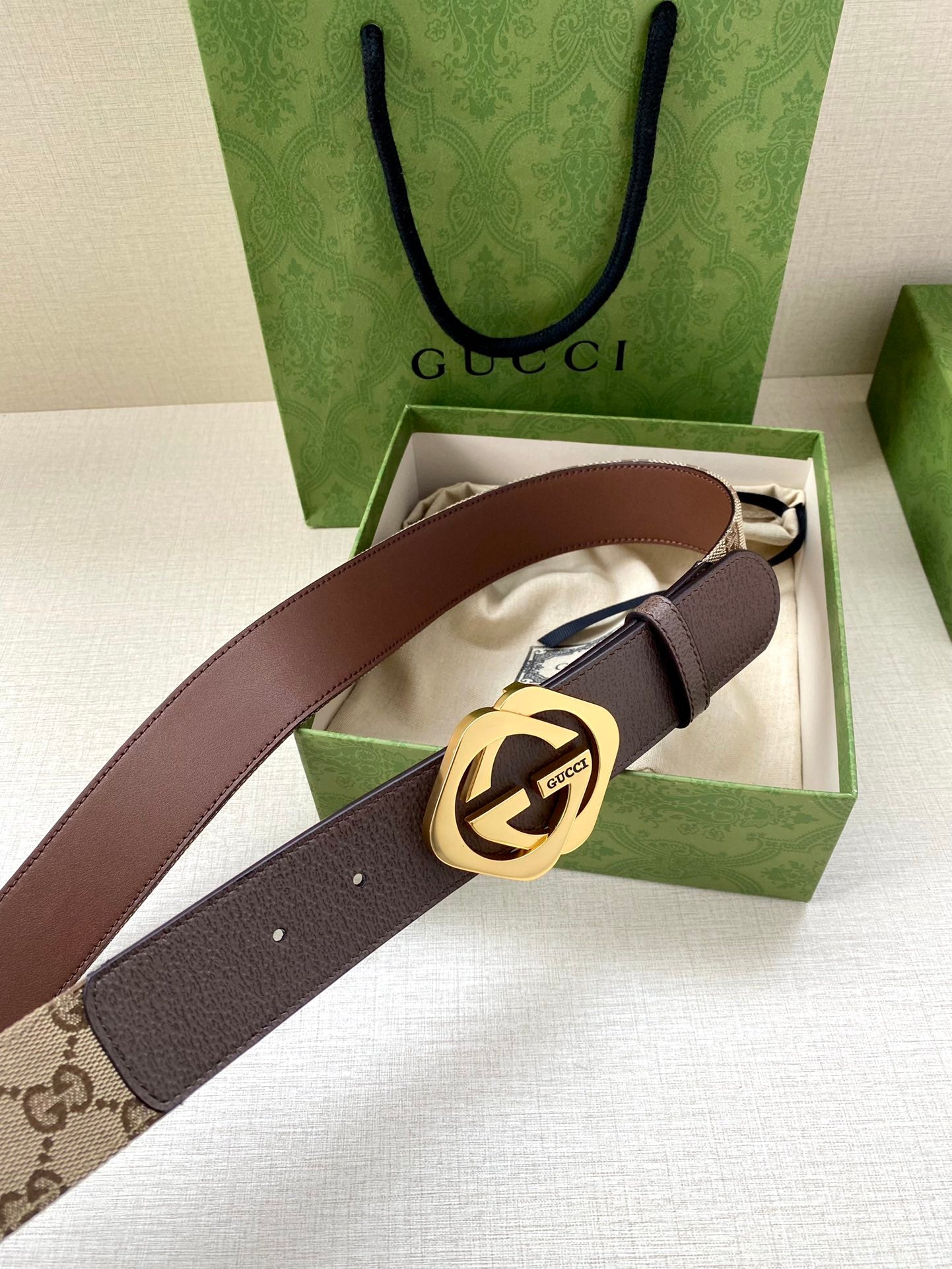Gucci belt with brown leather strap, beige monogram panel, and gold-tone buckle