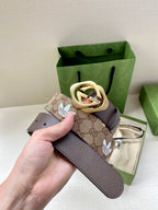 Gucci belt with beige monogram canvas section, dark leather strap, and gold-tone buckle