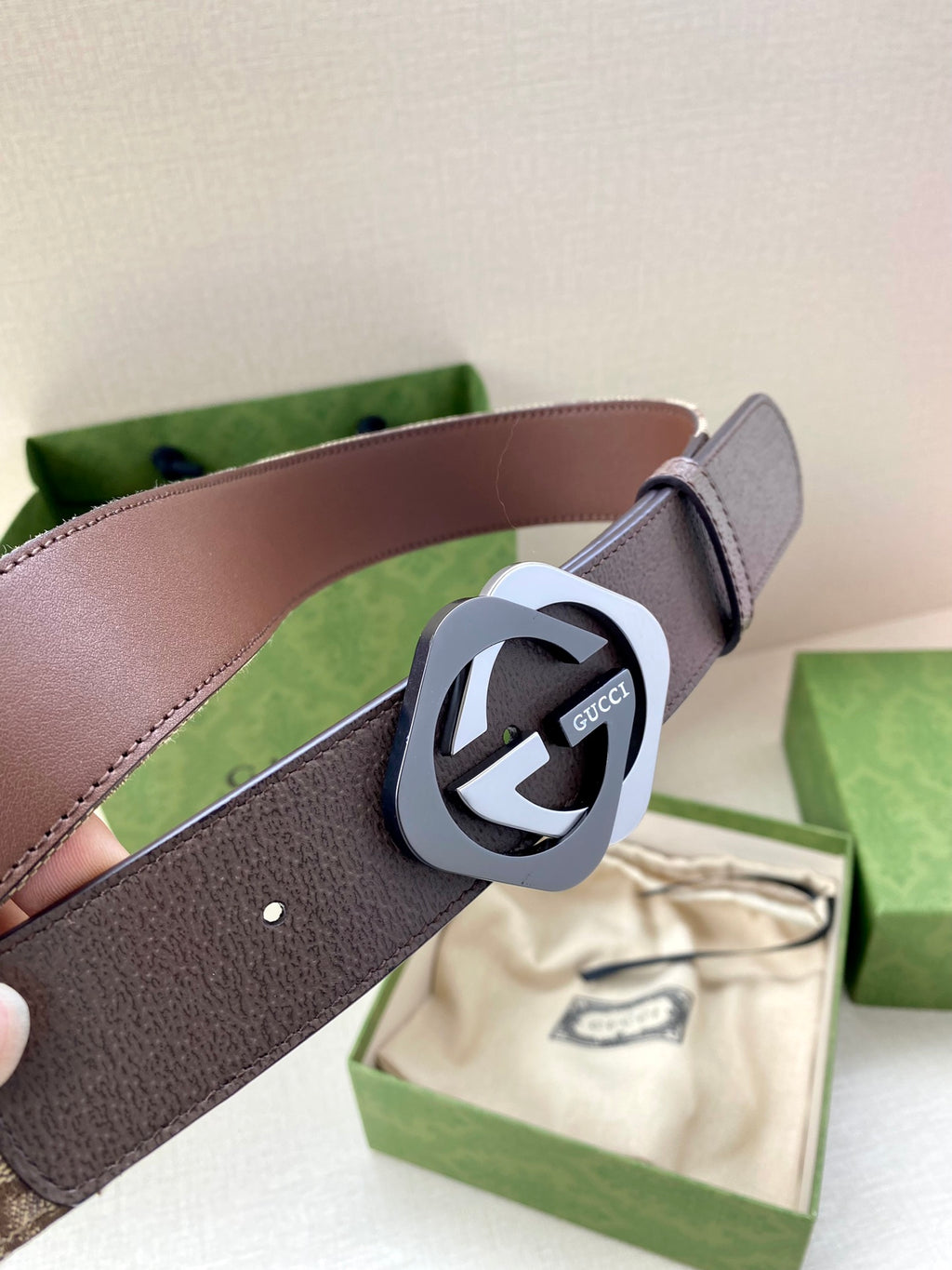 Gucci belt close-up with dark brown strap and GG-ring buckle