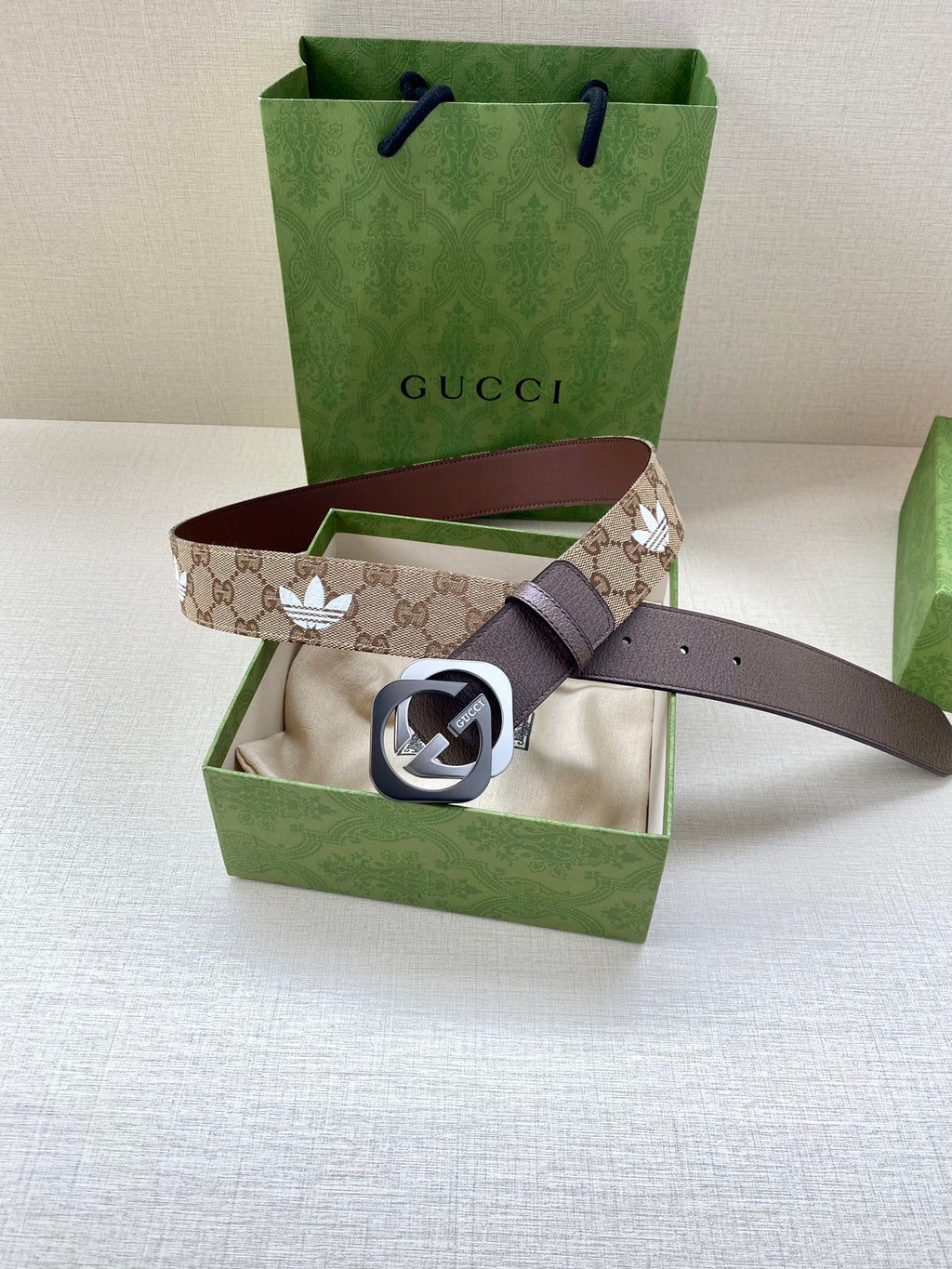 Gucci monogram belt with dark strap and GG buckle