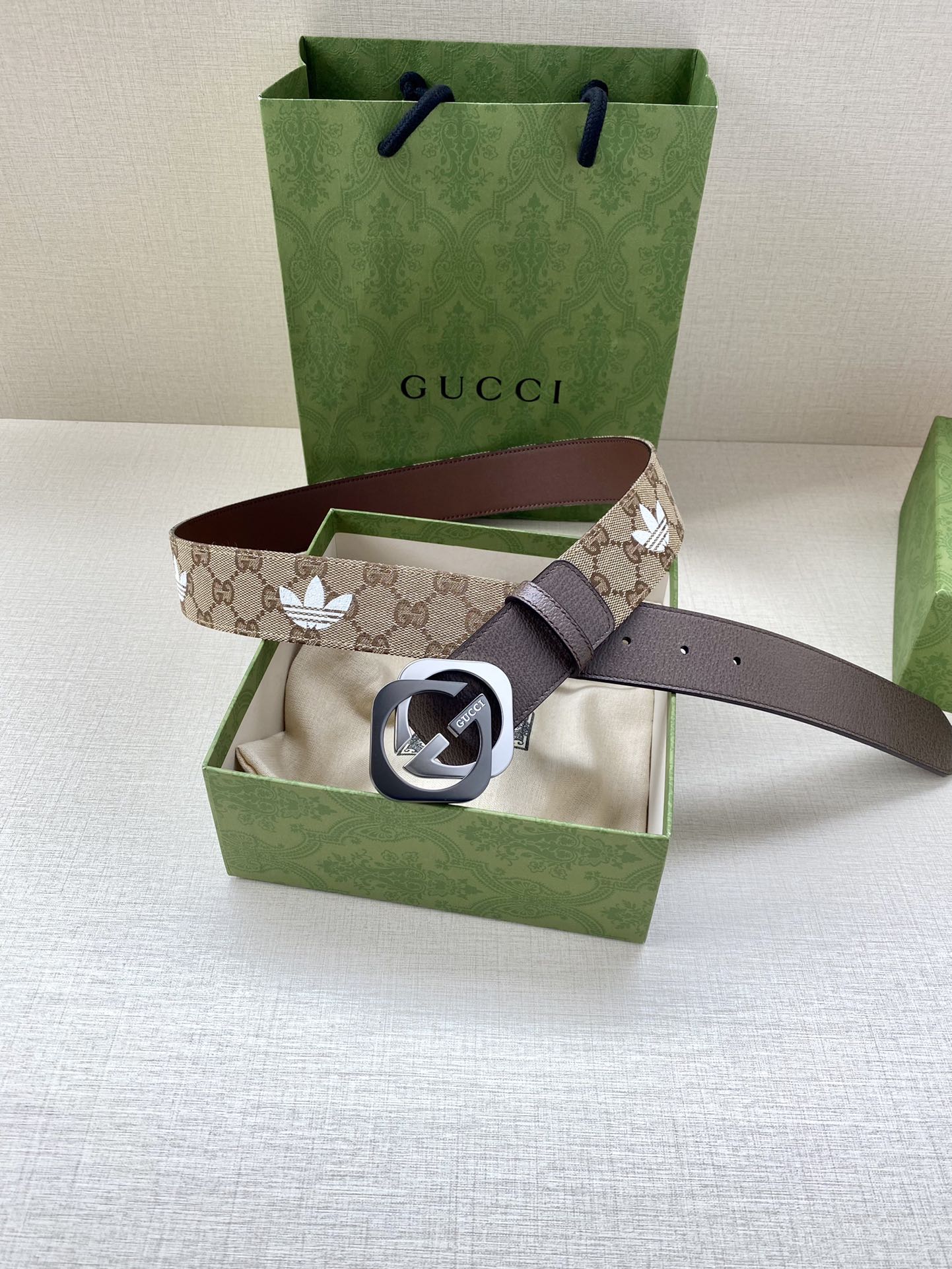 Gucci monogram belt with dark strap and GG buckle