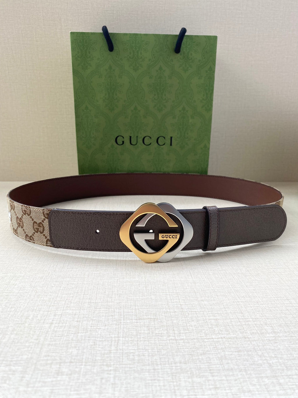 Gucci belt with dark strap and gold-tone circular logo buckle