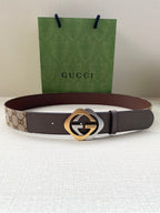 Gucci belt with dark strap and gold-tone circular logo buckle
