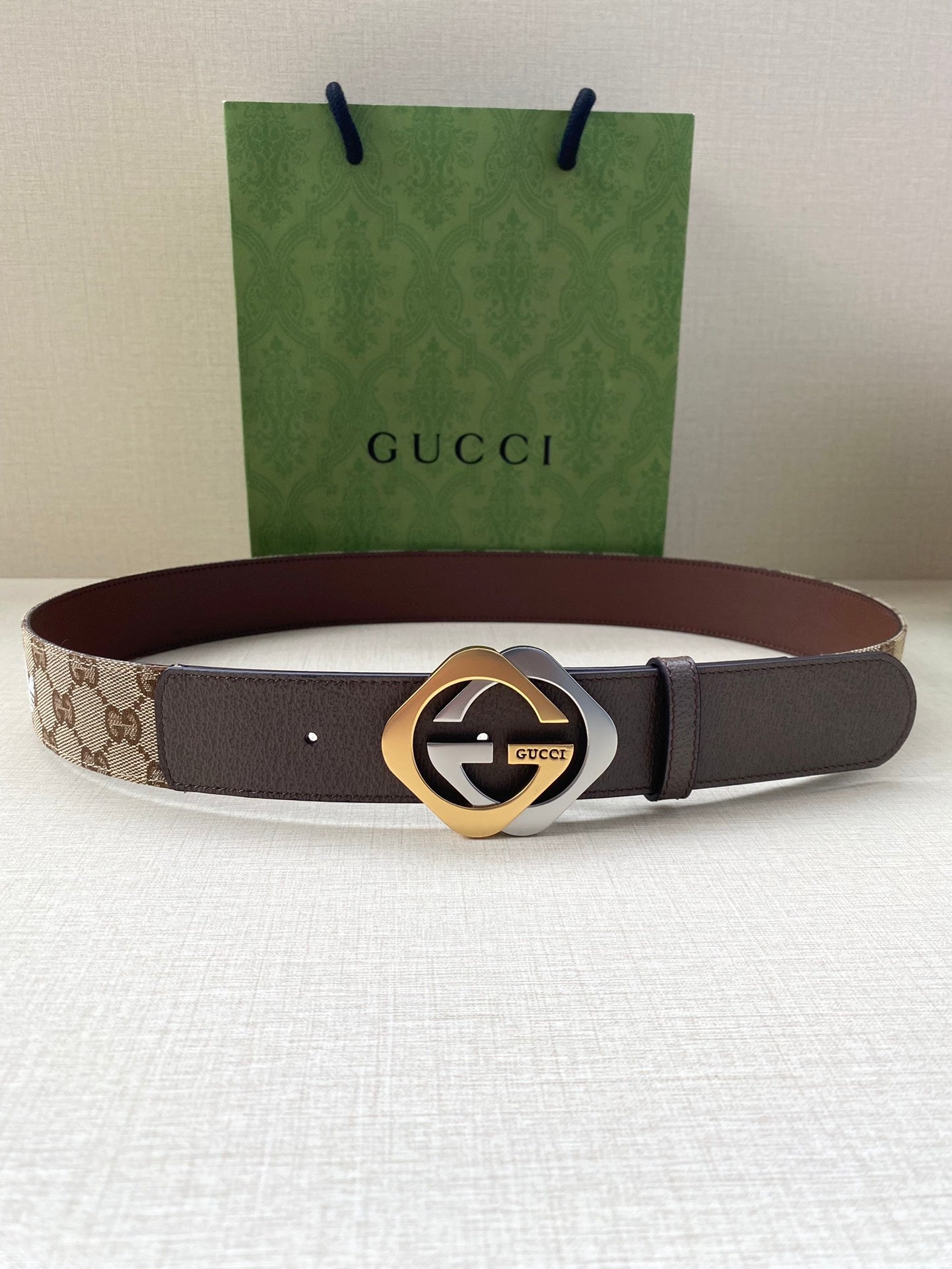 Gucci belt with dark strap and gold-tone circular logo buckle