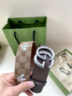 Gucci belt close-up: brown leather strap with GG monogram tab and silver double-G buckle