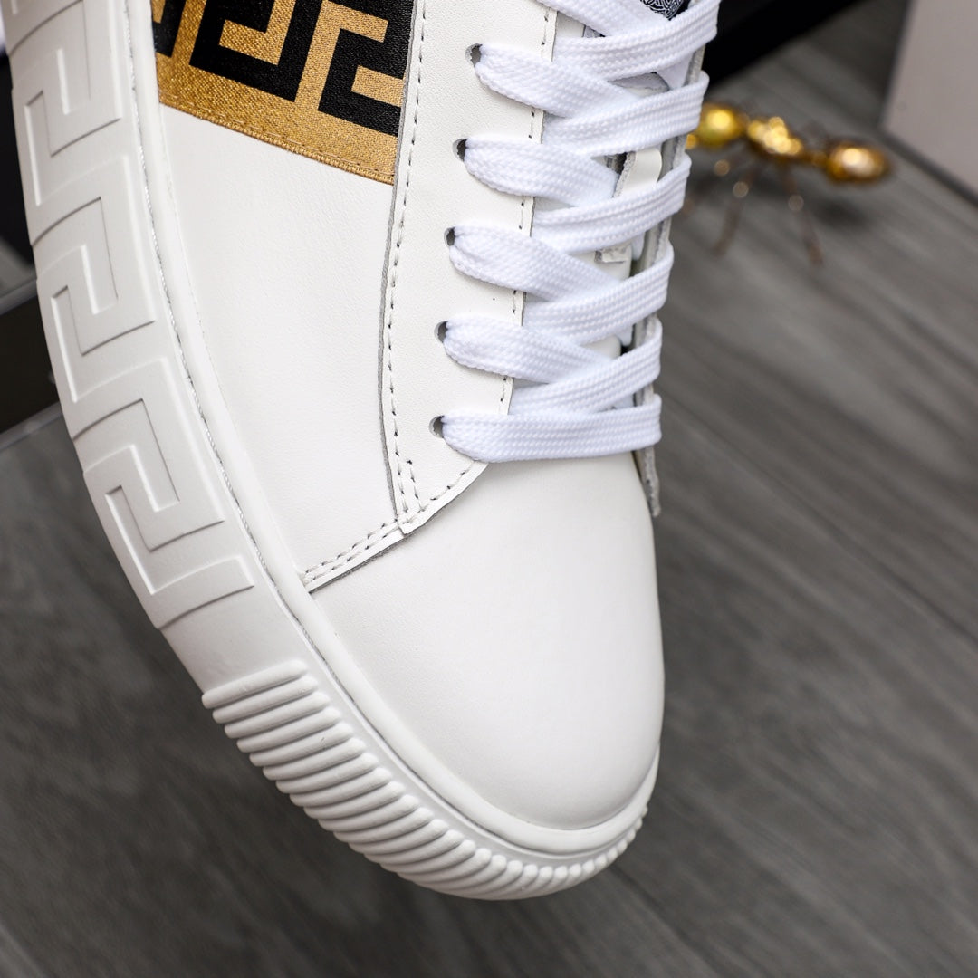 Close-up of white leather sneaker side panel with gold logo stripe and laces