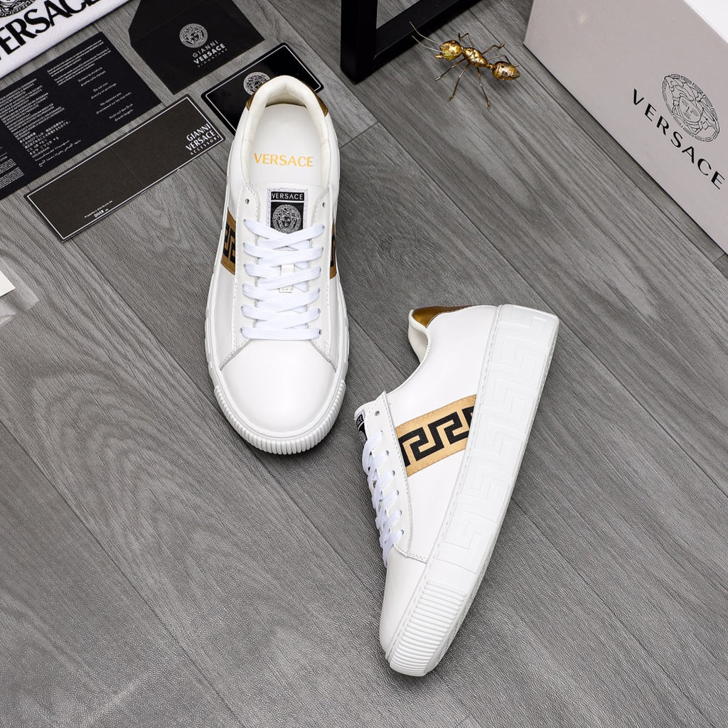 Pair of white low-top leather sneakers with gold logo stripe and gold heel lining