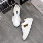 Pair of white low-top leather sneakers with gold logo stripe and gold heel lining