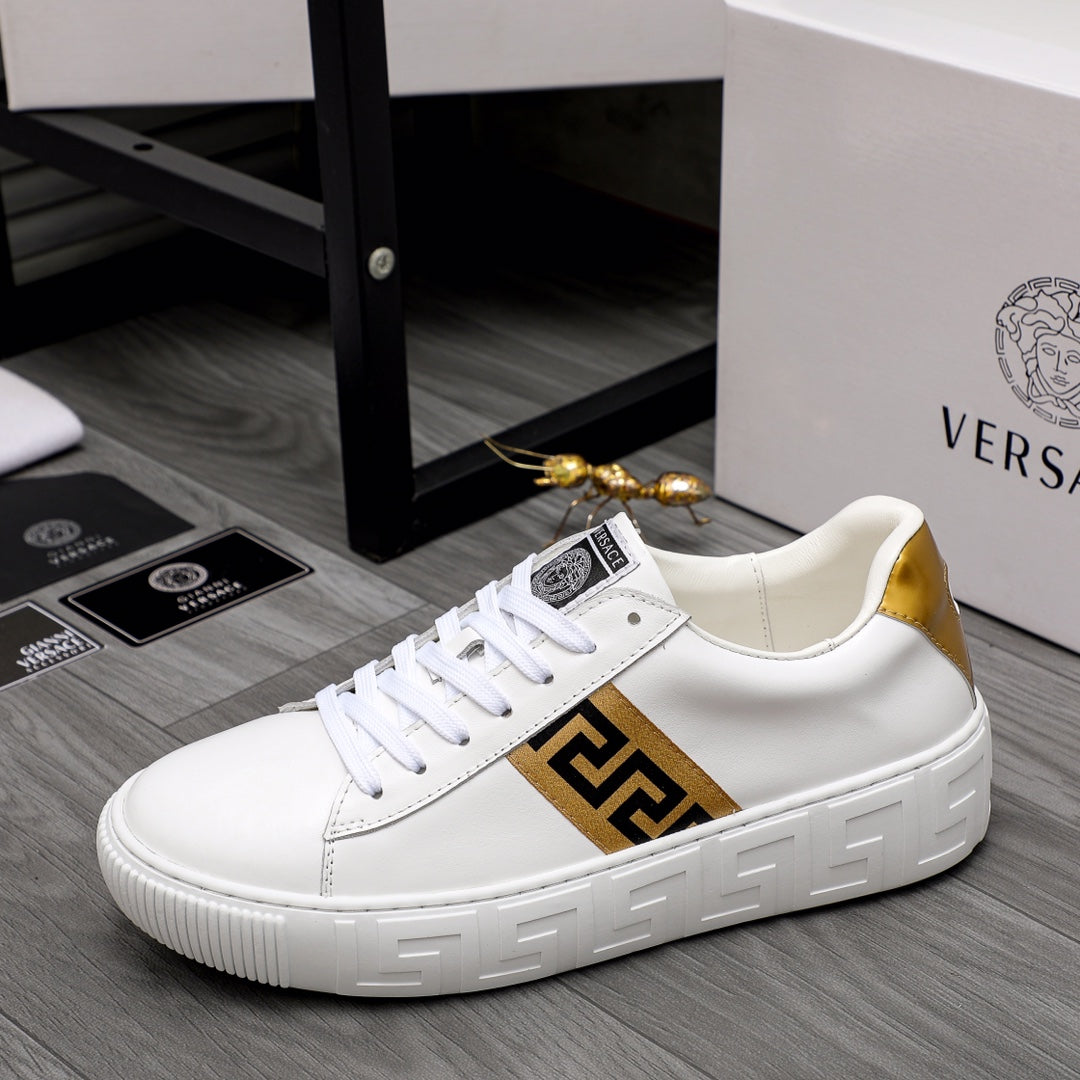 White leather low-top sneakers with gold logo panel and white textured outsole