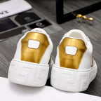 Rear view of white leather sneakers with gold heel panels and grippy outsole