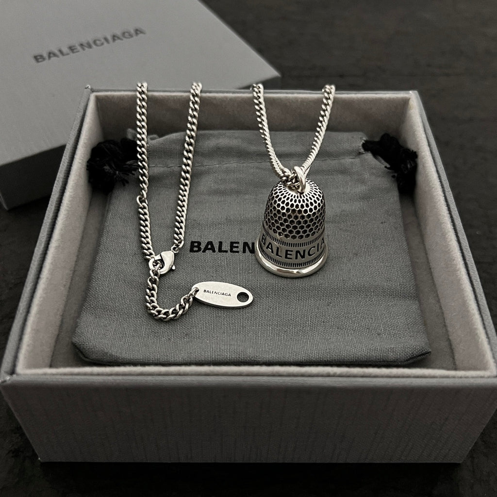 Silver-tone chain necklace set with mesh bell pendant and small oval logo tag