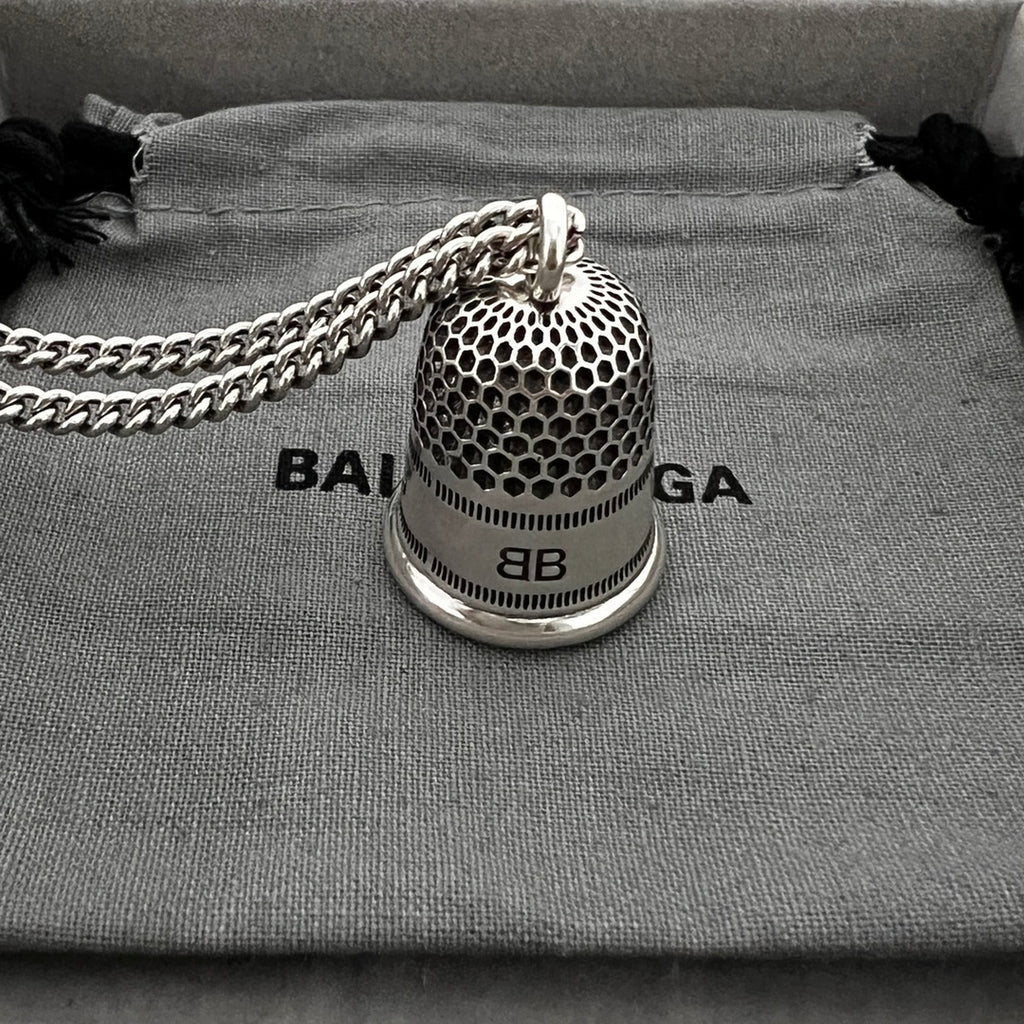 Close-up: silver mesh bell pendant with 8B label and logo band