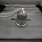 Close-up: silver mesh bell pendant with 8B label and logo band
