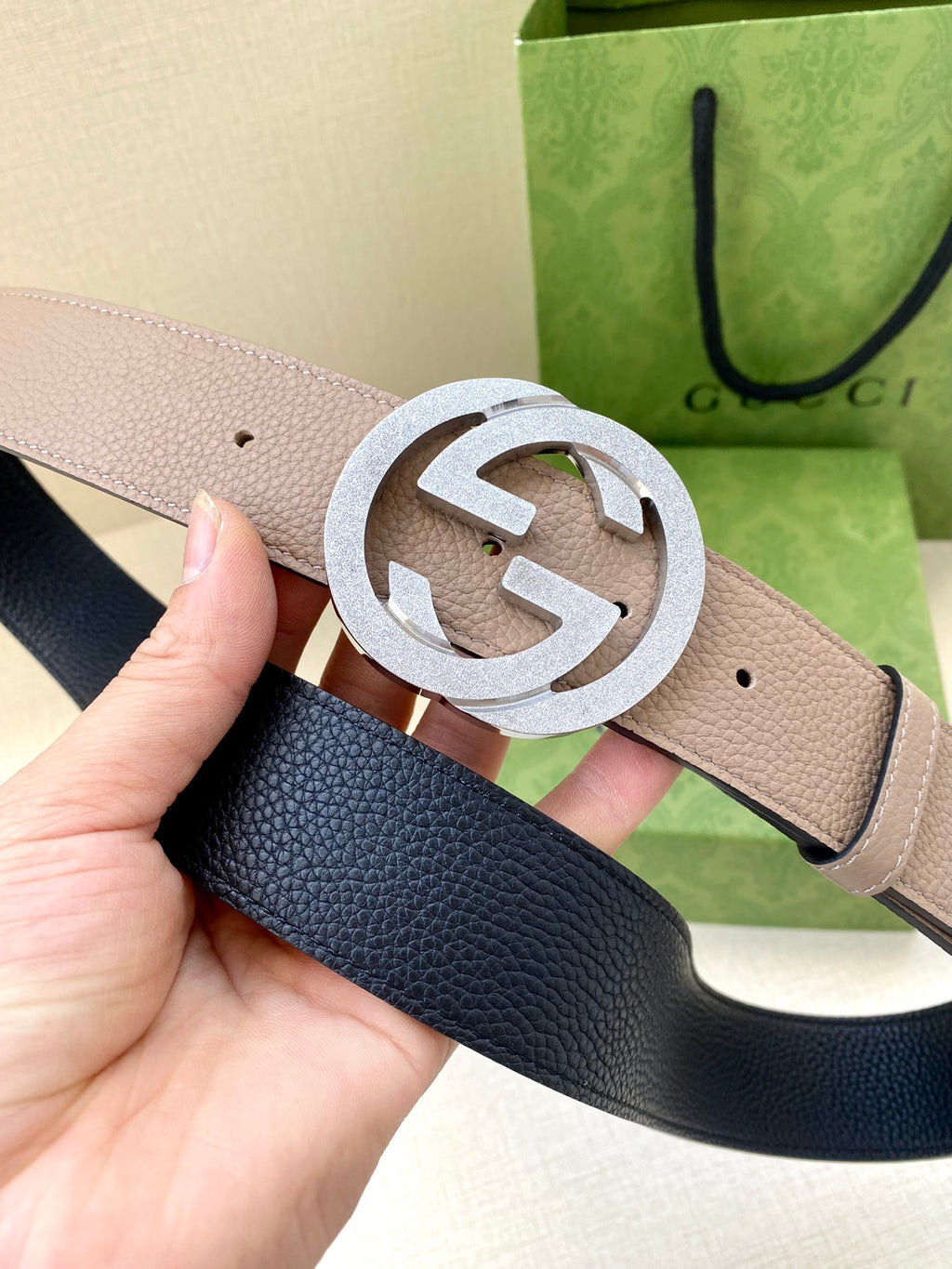 Gucci belt close-up: light taupe strap with large silver G buckle