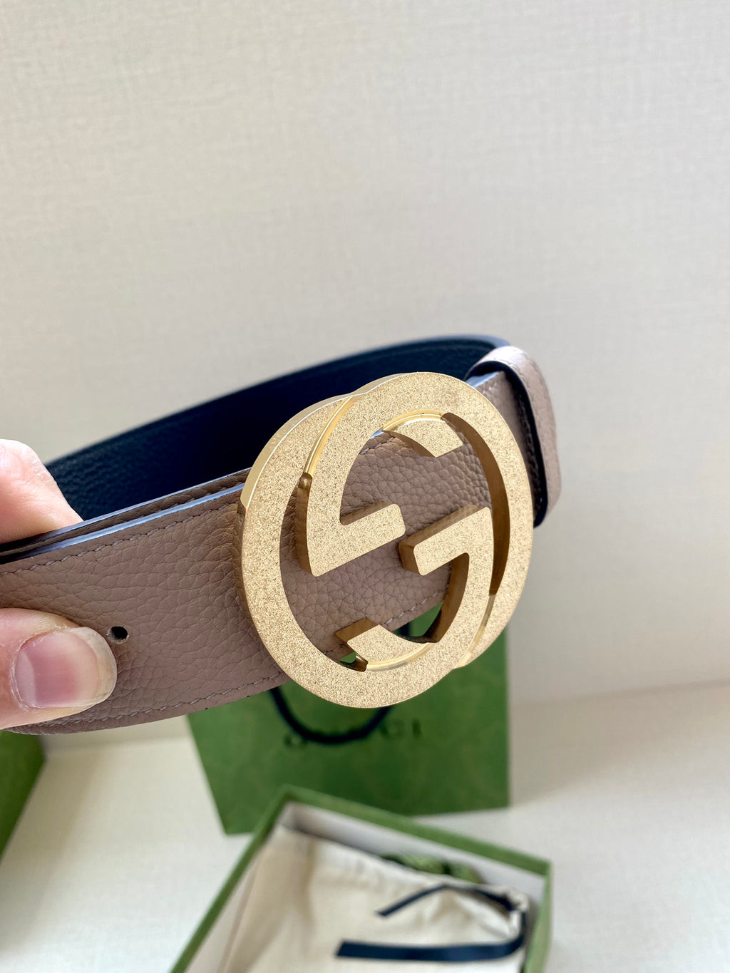 Gucci belt detail: taupe leather strap with gold round G buckle