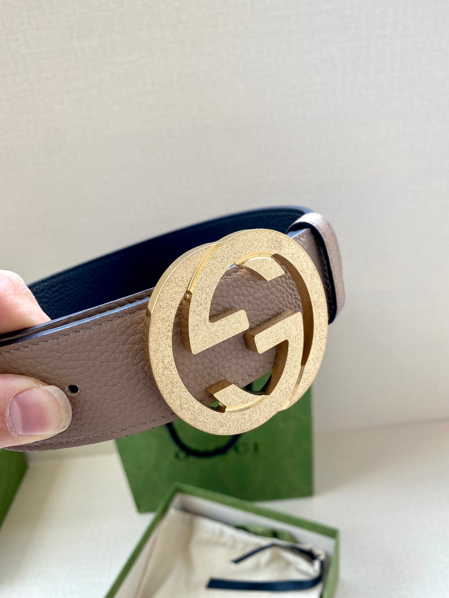 Gucci belt detail: taupe leather strap with gold round G buckle