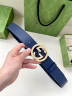 Navy leather belt with round gold logo buckle and single row of punched holes