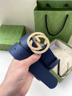 Navy leather belt with round gold logo buckle and textured strap