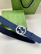 Navy leather belt close-up with silver logo buckle and punched holes