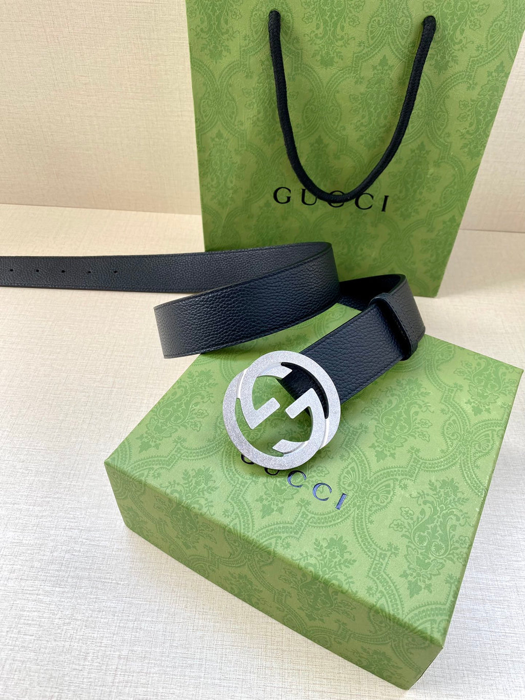 Navy leather belt with round silver GG logo buckle, flat strap end and studs