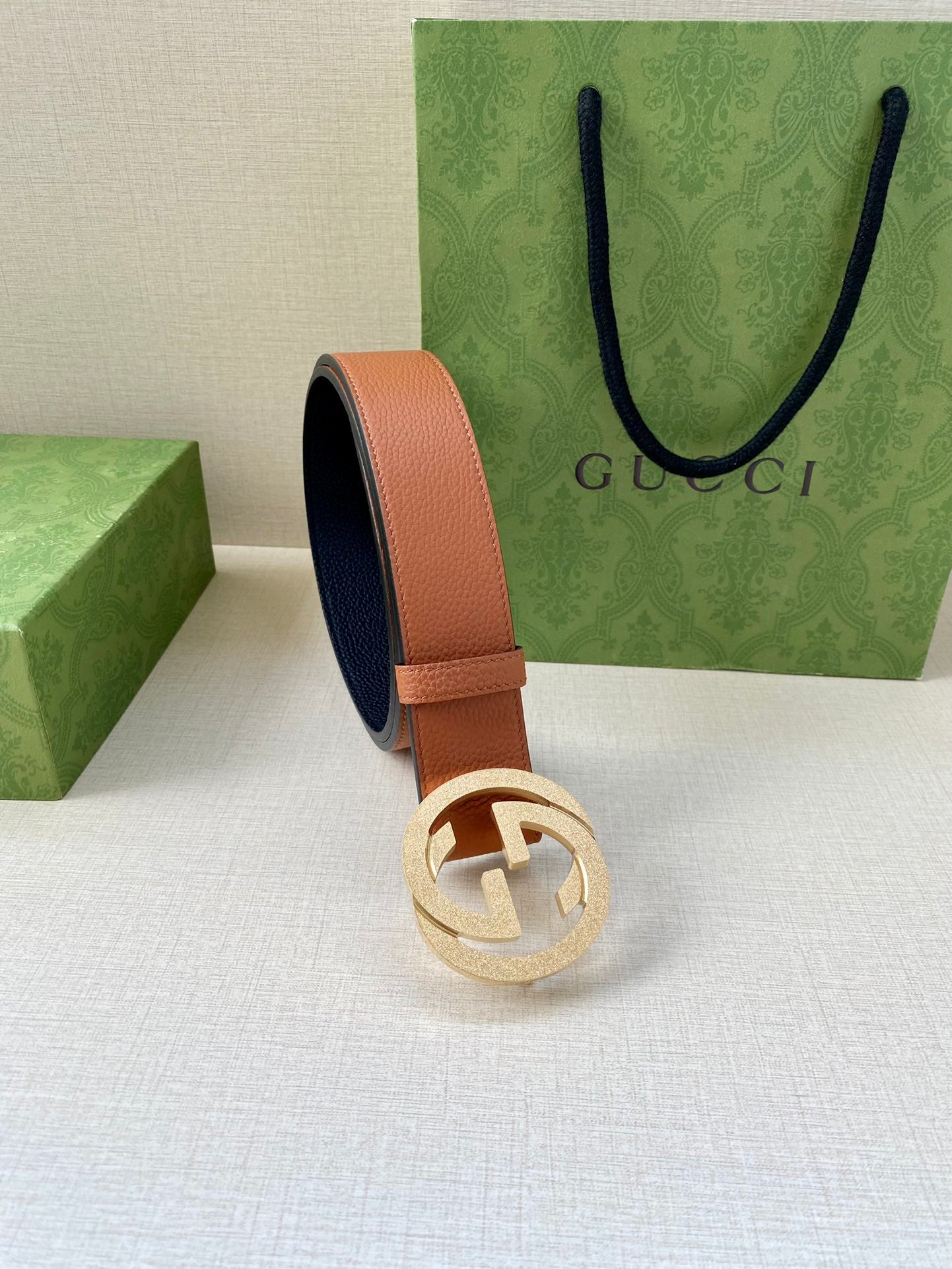 Gucci belt with tan leather strap and silver GG buckle, side view