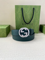 Teal leather belt with interlocking logo buckle and dark blue-green tone