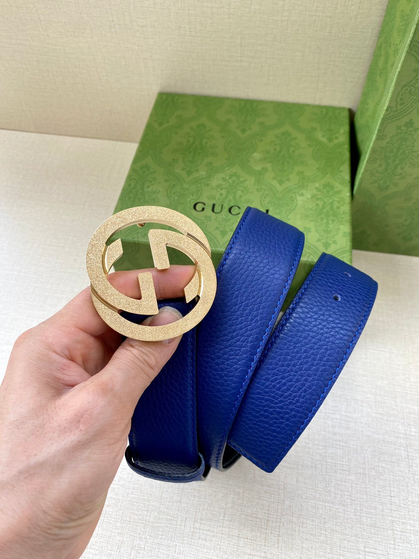 Gucci belt with blue leather strap and gold-tone circular GG buckle