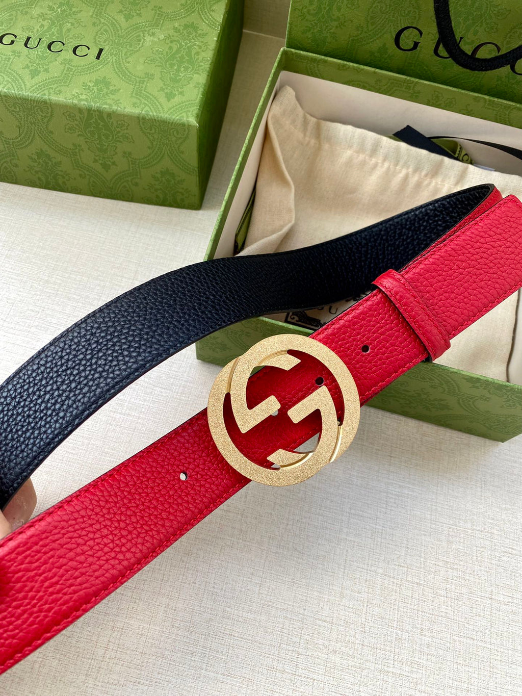 Red and navy leather belt with gold-tone interlocking G buckle, worn strap end