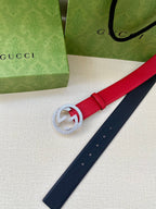 Red leather belt end with silver-tone interlocking G buckle, navy strap beside it