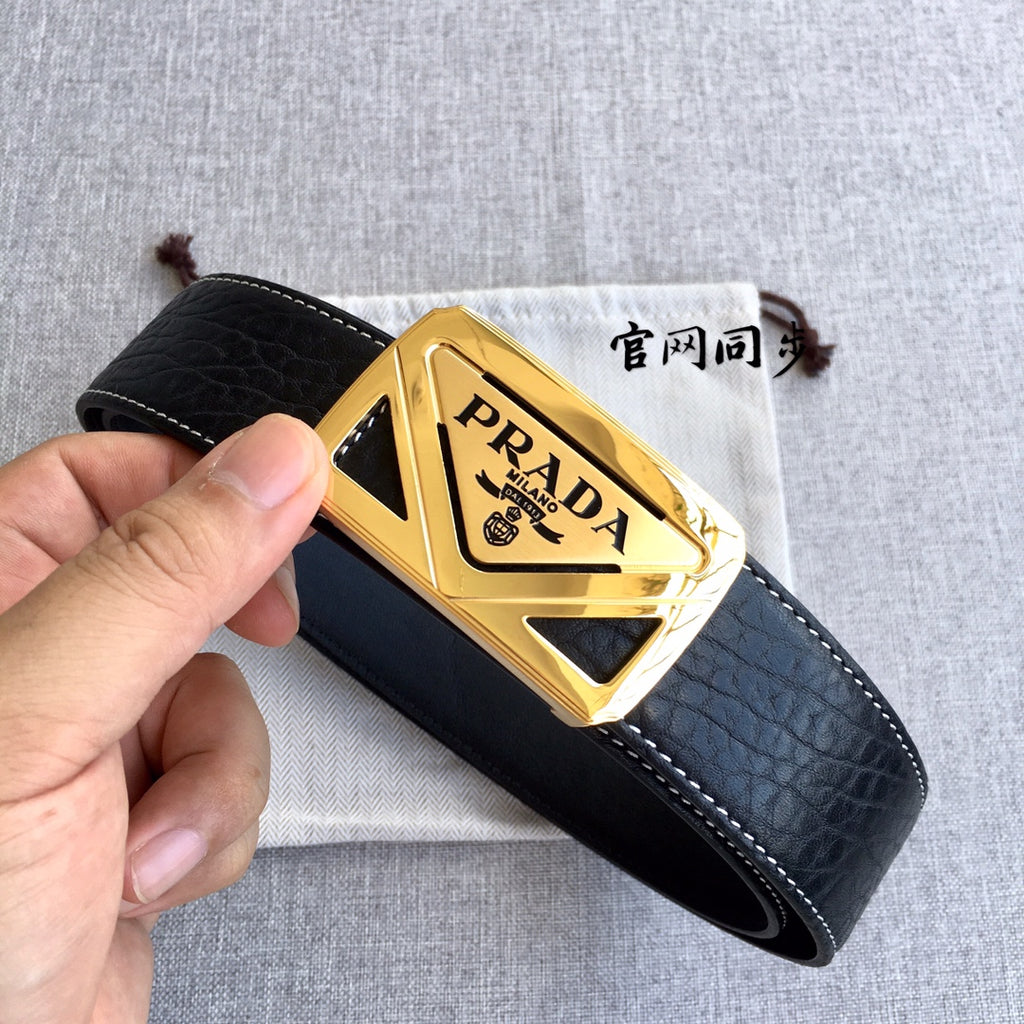 Prada leather belt, black strap and gold triangular buckle held in hand