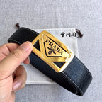 Prada leather belt, black strap and gold triangular buckle held in hand