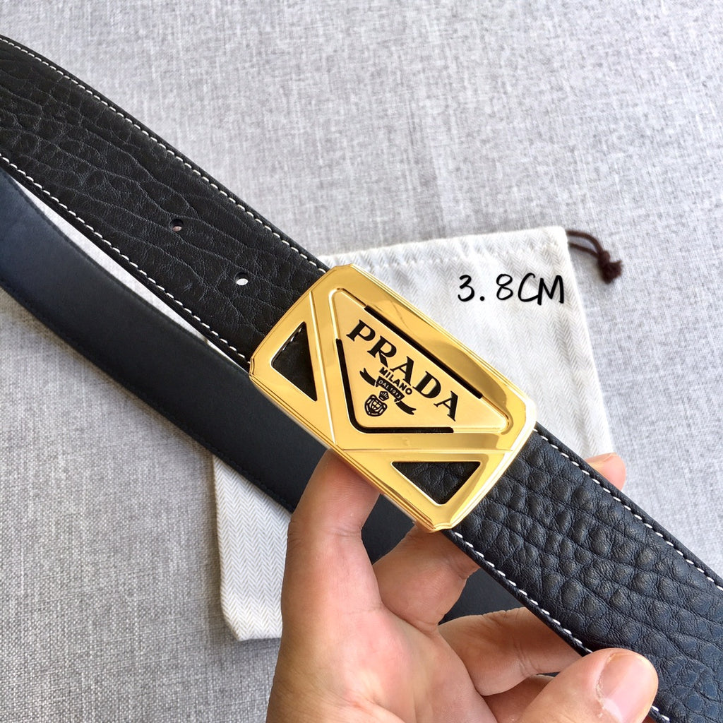 Prada belt buckle close-up on black textured strap with gold PRADA hardware