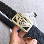 Prada belt buckle detail on black leather strap with gold-toned metal frame
