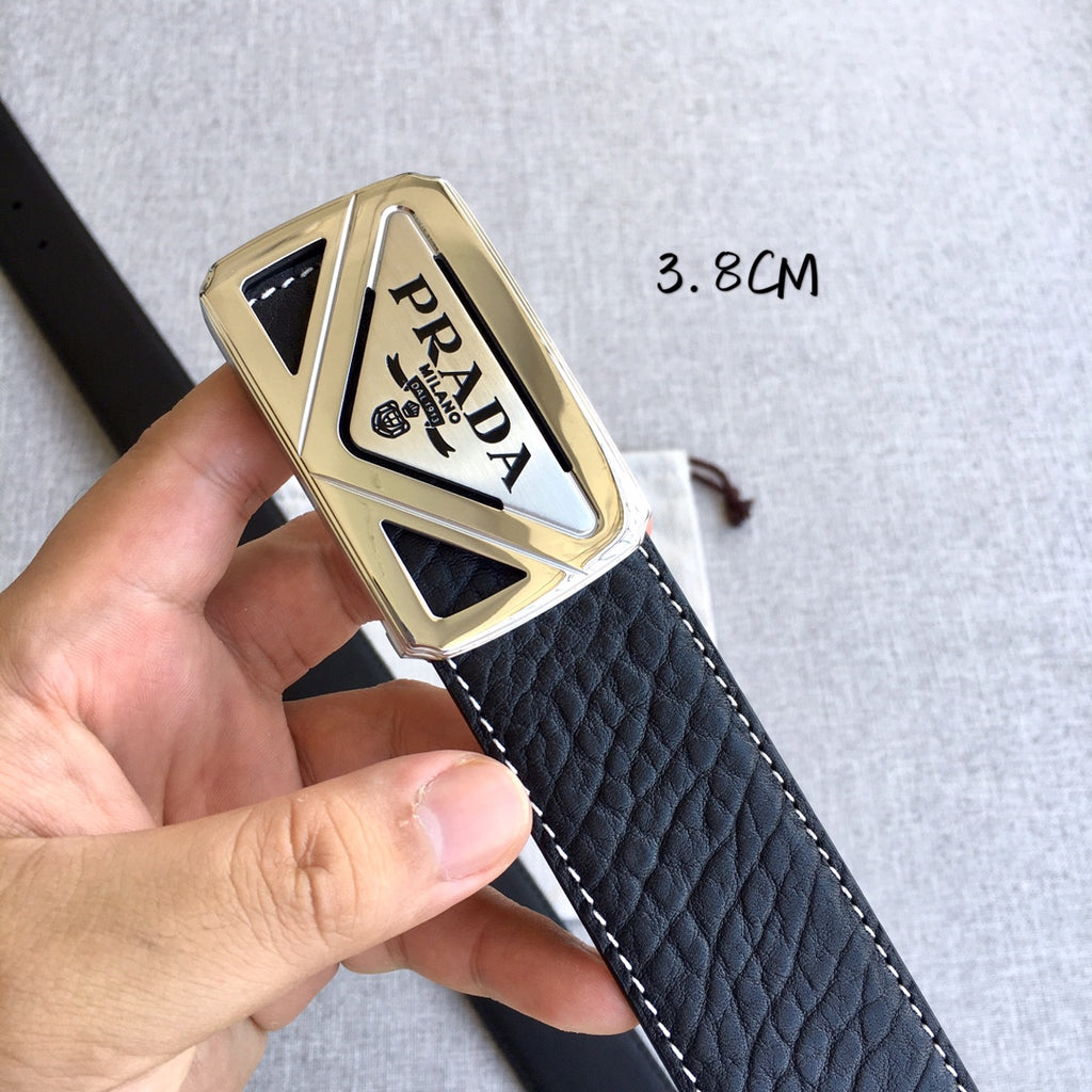 Prada belt buckle close-up on dark strap with gold-toned triangular metal frame