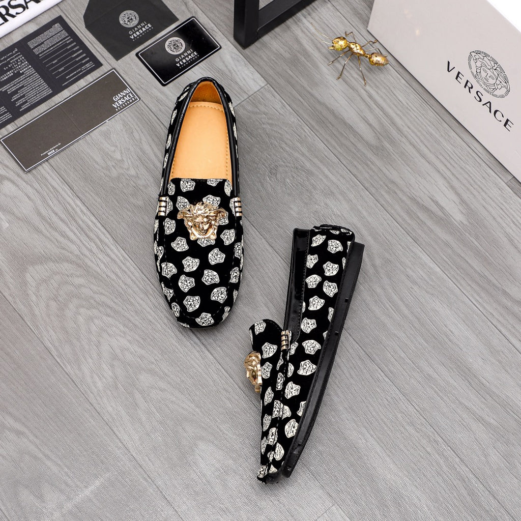 Versace luxury loafers pair, black slip-ons with white patterned print and gold lion emblem