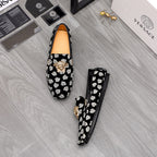 Versace luxury loafers pair, black slip-ons with white patterned print and gold lion emblem