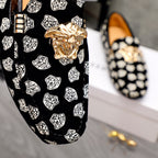 Versace luxury loafer upper close-up, black with white pattern print and gold lion head