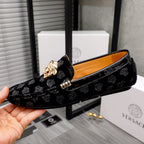 Black luxury loafers side view with gold Medusa emblem and buckle detail