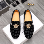 Black patterned luxury loafers with gold Medusa emblem and decorative buckle