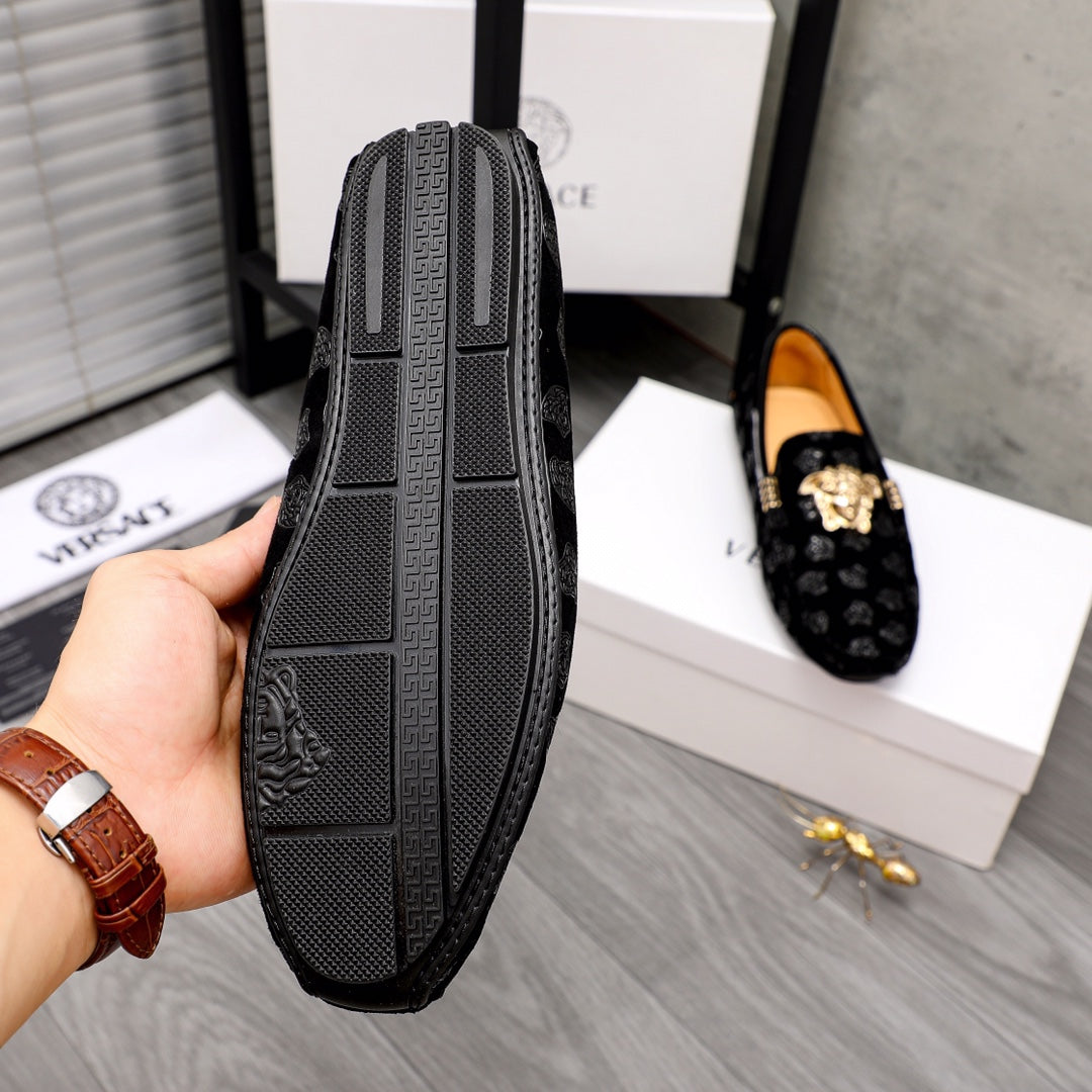 Black loafer outsole view with textured tread and embossed Medusa logo