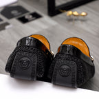 Black loafers with textured back panels and Greek key logo detail