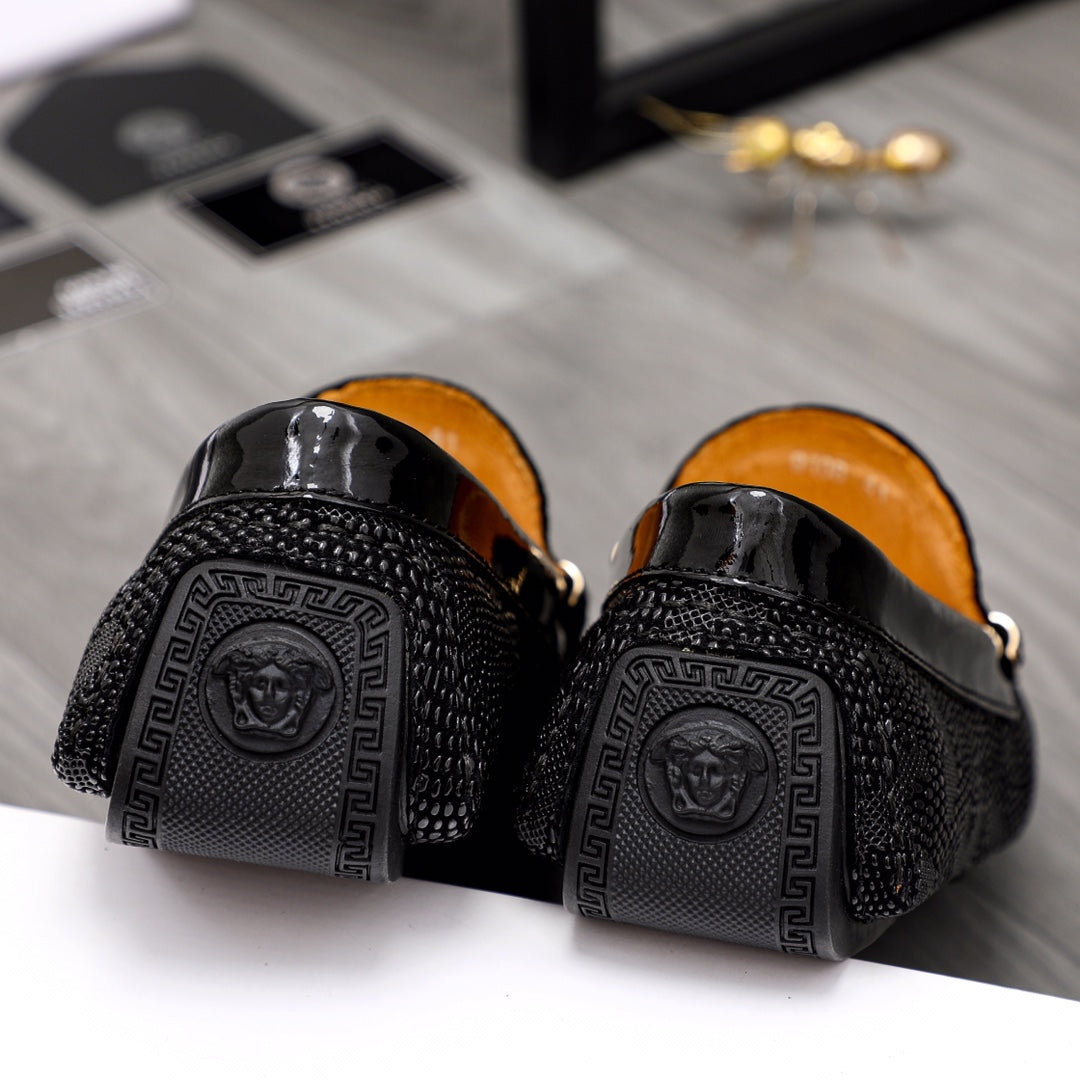Black loafers with textured back panels and Greek key logo detail