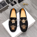Black Versace-style loafers with gold Medusa emblem and studded accents