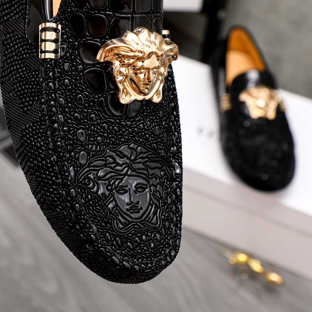 Versace black loafers close-up of gold Medusa head and textured finish