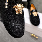 Versace black loafers close-up of gold Medusa head and textured finish