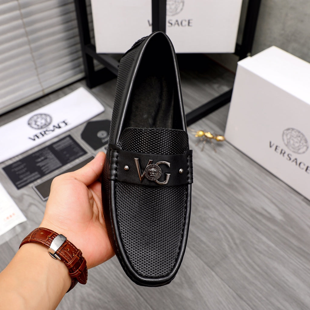 Versace black slip-on loafer showing front vamp texture and Medusa buckle