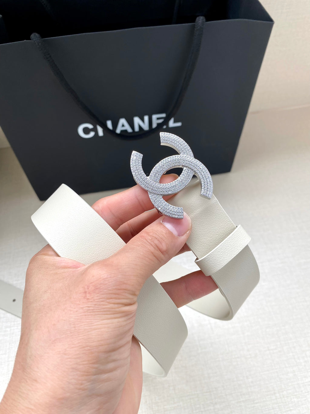 Chanel belt held up: light cream leather strap with stud holes and glitter CC buckle