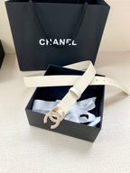 Chanel belt light cream with stud holes and glitter CC buckle on display