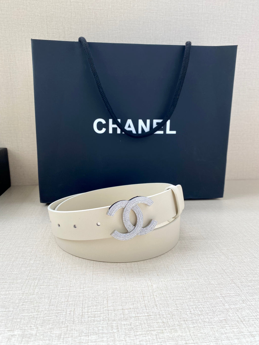 Chanel belt light cream leather with stud holes and rhinestone CC buckle, front view